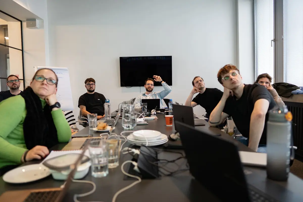 Tím sústredene sleduje prezentáciu na workshope